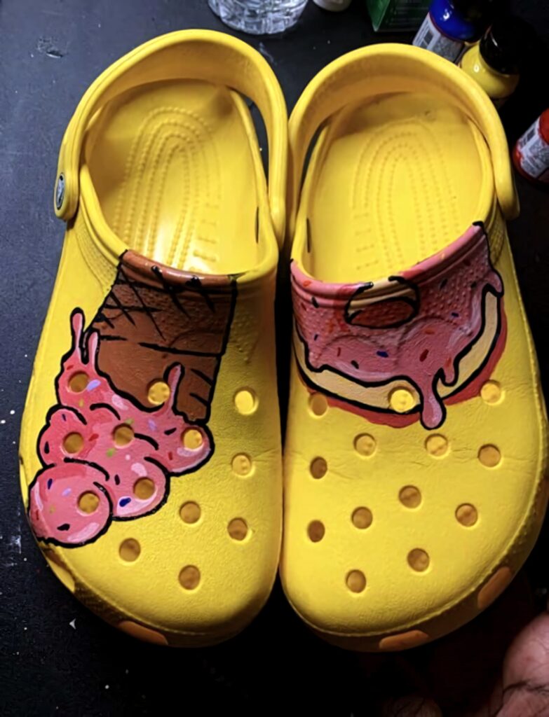Vibrant yellow Crocs with hand-painted melting ice cream cone and pink frosted donut designs Wallpaper