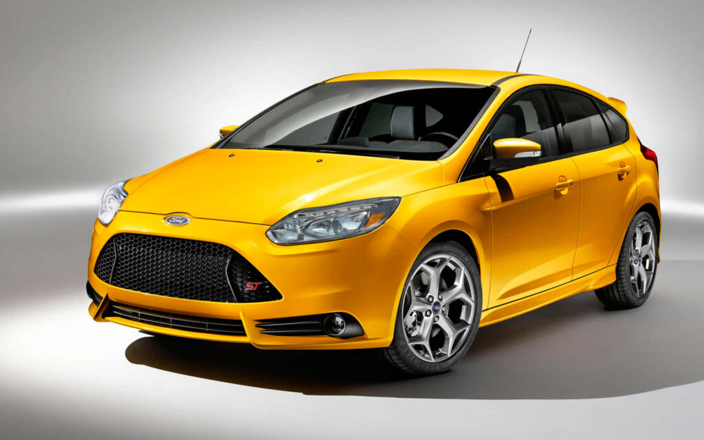 Yellow Ford Focus ST sporty car on road dynamic design stylish wallpaper background