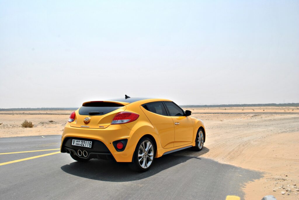 Vibrant Yellow Hyundai Veloster in Stunning Desert Landscape Wallpaper