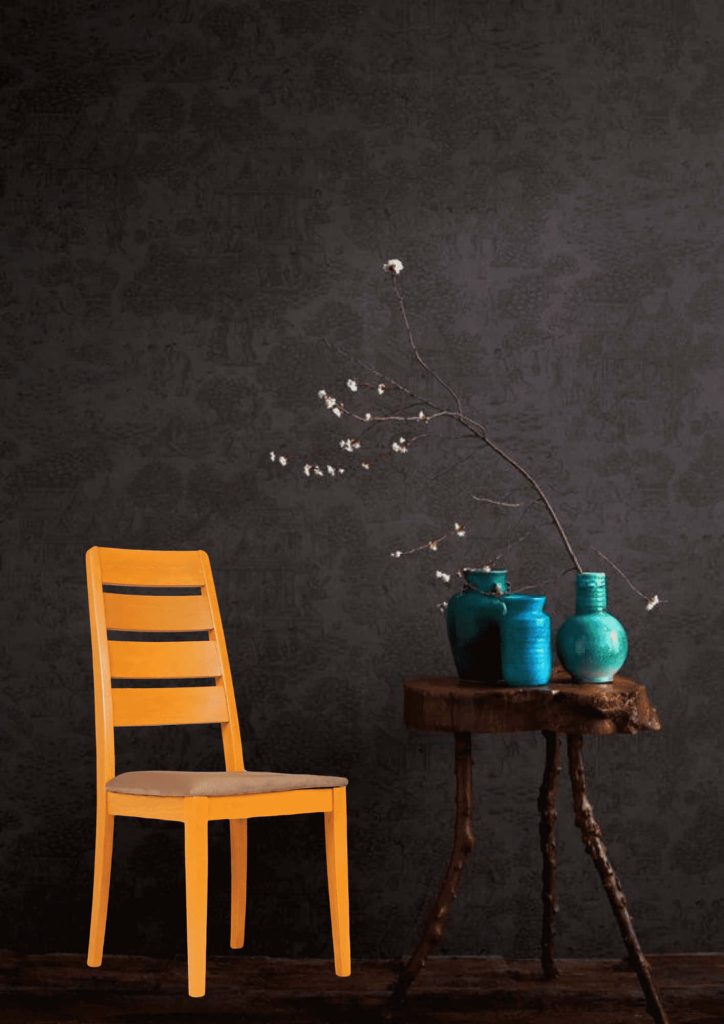 Vibrant yellow ladder-back chair by rustic live-edge table with teal vases on dark wallpaper