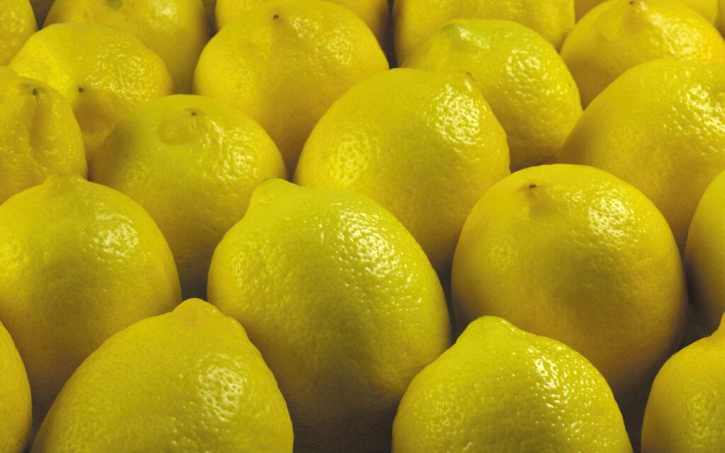 Vibrant Yellow Lemon Wallpaper: Cheerful & Glossy Background