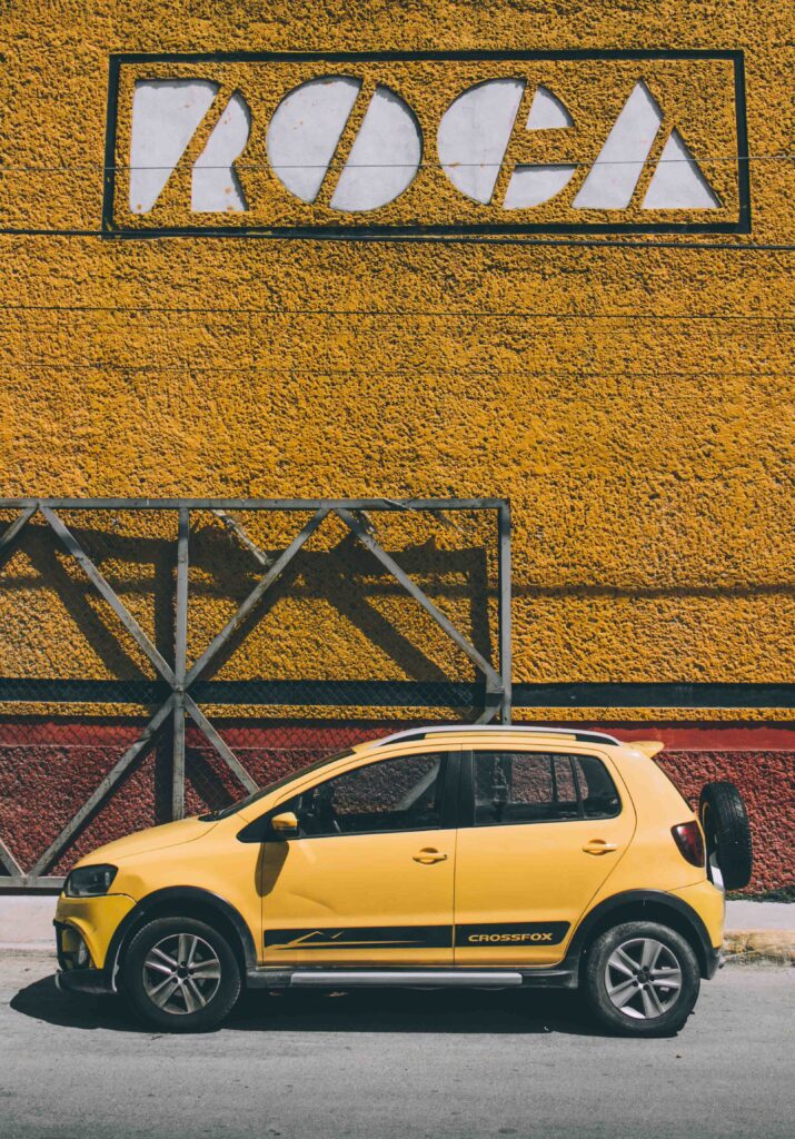 Vibrant Yellow Mini SUV Against Bold Geometric Wall - Urban Scene Wallpaper