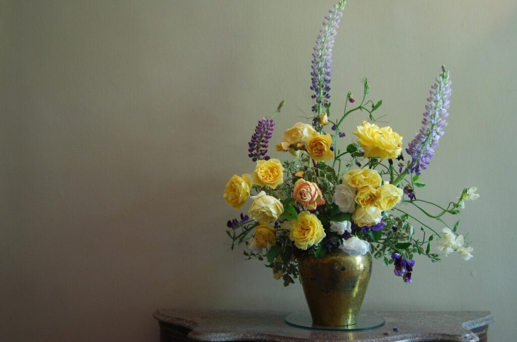 Vibrant Yellow and Orange Roses in Rustic Vase - Serene Background Wallpaper