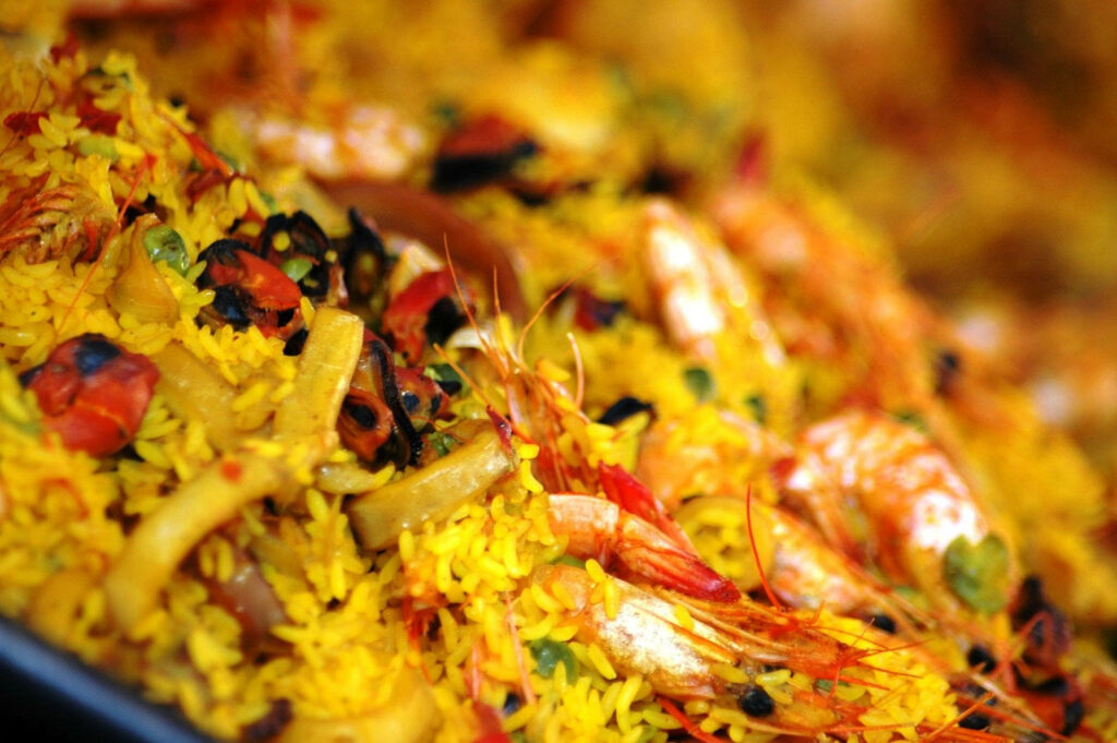 Vibrant Yellow Paella Rice with Seafood - Stunning Wallpaper Background