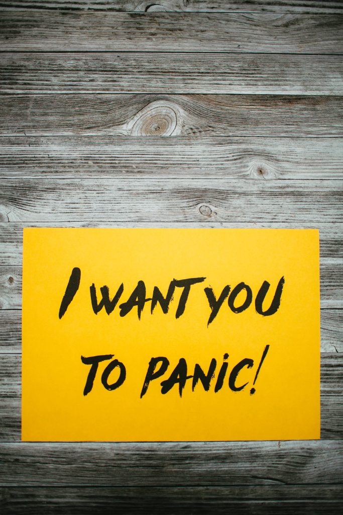 Yellow note with bold I WANT YOU TO PANIC text on rustic gray wood background wallpaper