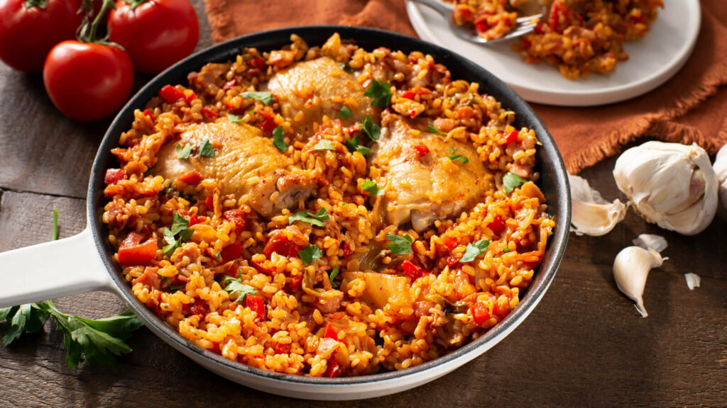 Vibrant Paella Wallpaper: Hearty Chicken & Veggie Dish in Rustic Pan