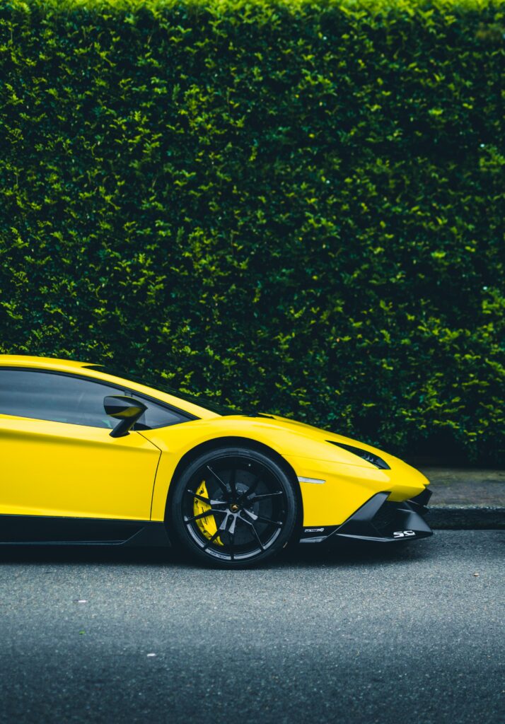 Vibrant Yellow Sports Car in Dynamic Green Background - Sleek Design Wallpaper