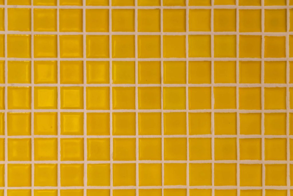 Vibrant yellow tile pattern wallpaper with glossy squares and clean white grout lines background