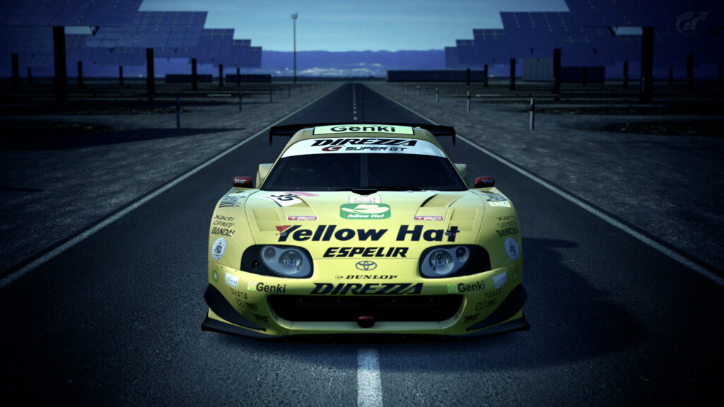 Yellow Toyota sports car with racing decals on open road sharp 4K dynamic design wallpaper