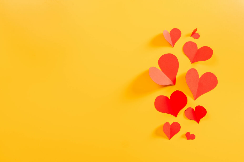 Charming Yellow Wallpaper with Red & Pink Heart Cutouts
