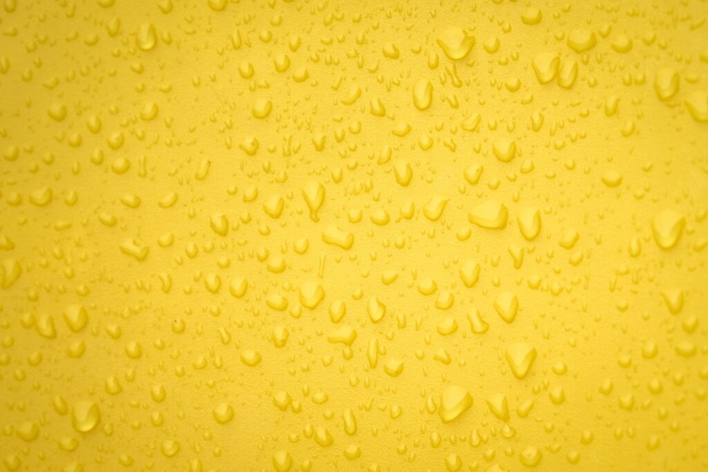 Vibrant Yellow Wallpaper with Water Droplets - Refreshing Background
