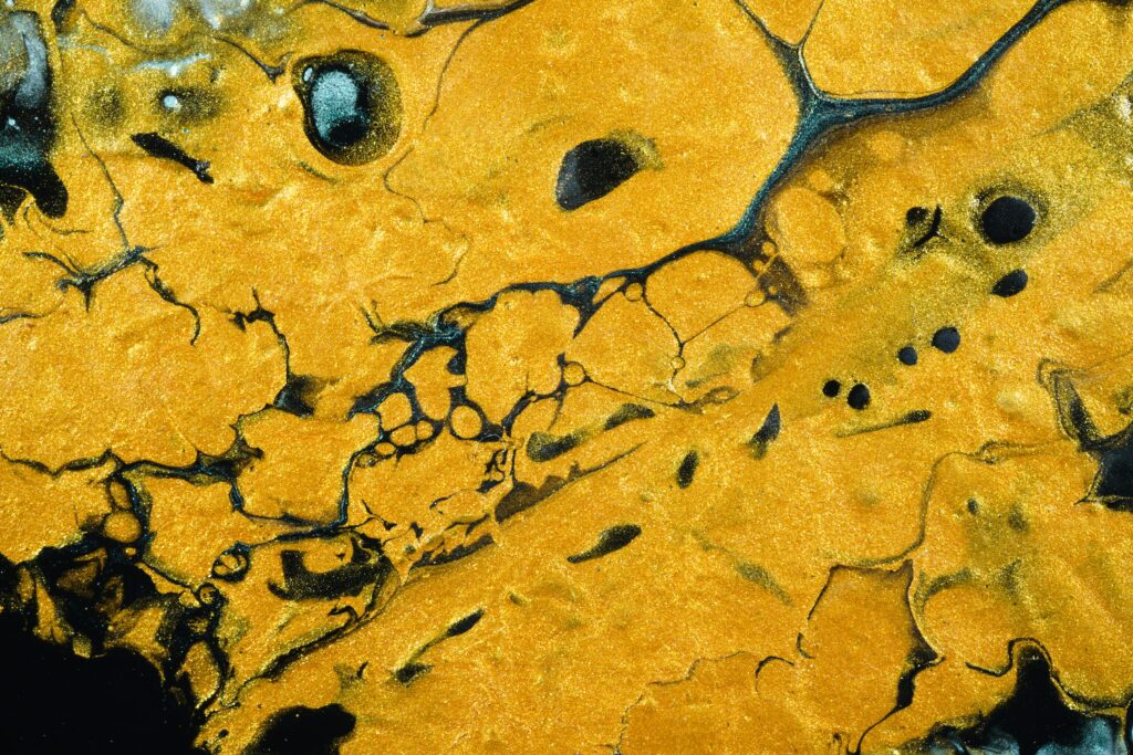 Vibrant Yellow and Black Abstract Wallpaper with Dynamic Liquid Patterns