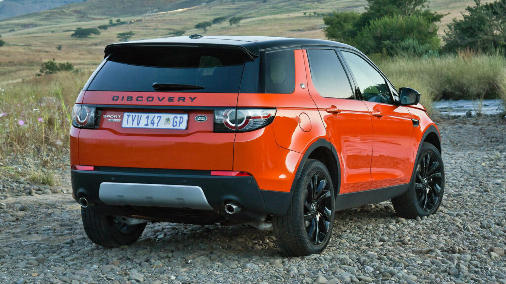 Vibrant iPhone Wallpaper: Dark Orange Land Rover on Rocky Terrain
