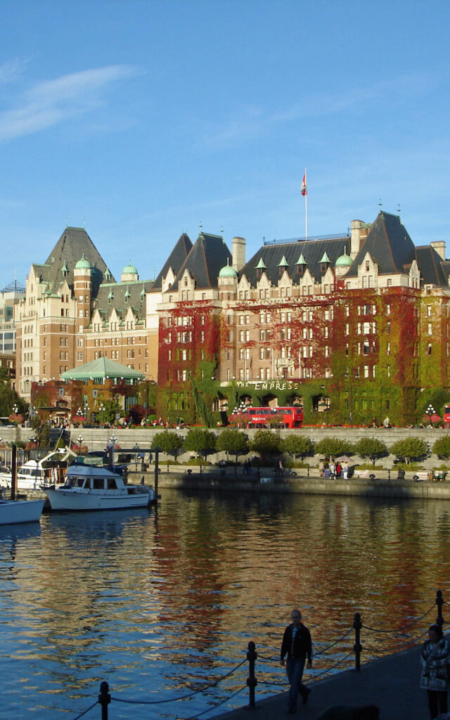 Scenic Victoria Harbour Canada with historic ivy-covered buildings boats and calm waterfront reflections Wallpaper