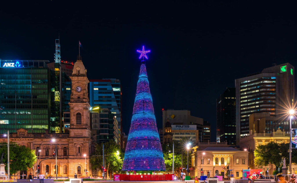 Illuminated Christmas tree in Victoria Square Adelaide with festive lights on historic buildings Wallpaper