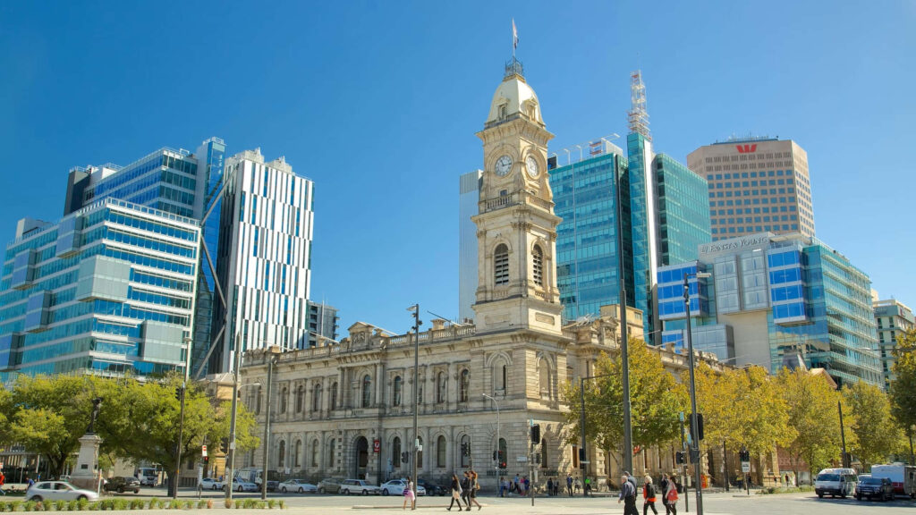 Victoria Square Adelaide with historic Town Hall and modern glass buildings under clear sky Wallpaper