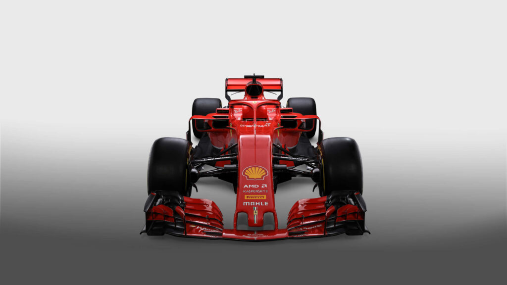 Roaring Power: Captivating F1 2018 Snapshot Featuring the Red Ferrari SF71H Racer amidst a Striking Monochromatic Canvas Wallpaper