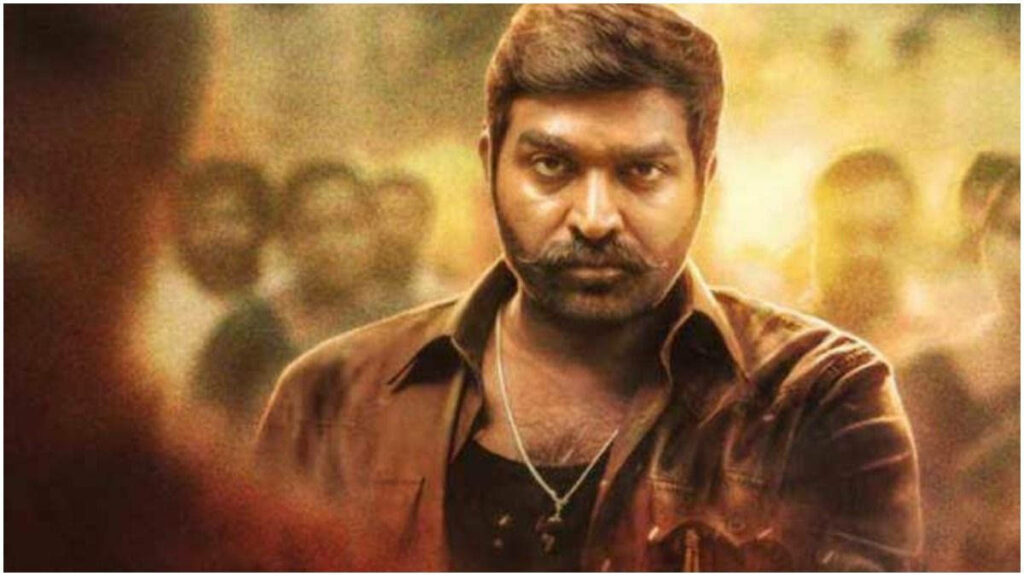 The Masterful Vijay Sethupathi Strikes a Pose in a Brown Jacket, Surrounded by an Enthralling Group Wallpaper