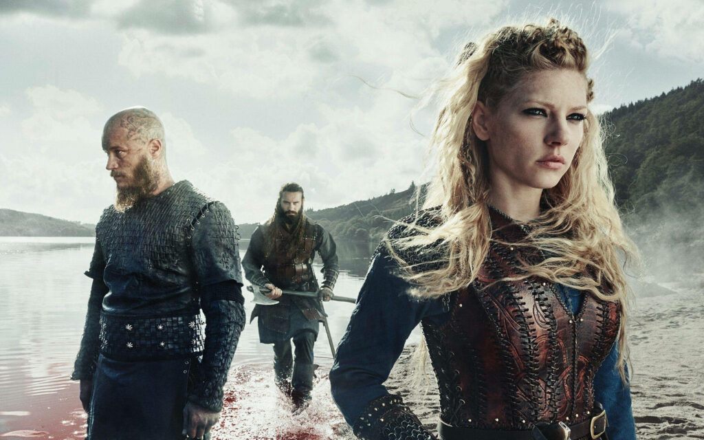 Blood and Glory: Vikings Ragnar, Rollo, and Lagertha Pose Before the Slightly Bloody Sea Wallpaper