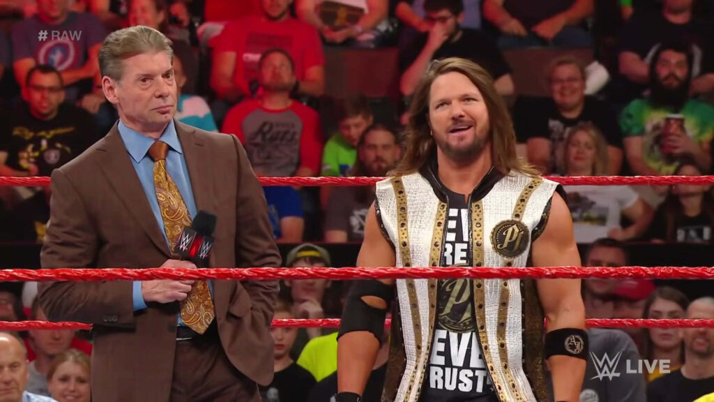 WWE Commentator Vince McMahon talks with AJ Styles in ring during live event with crowd Wallpaper