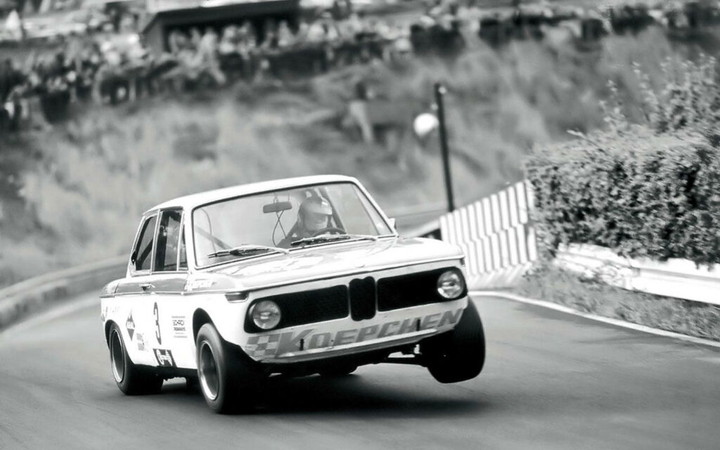 Vintage BMW 2002tii racing on track monochrome classic car dynamic motion wallpaper background