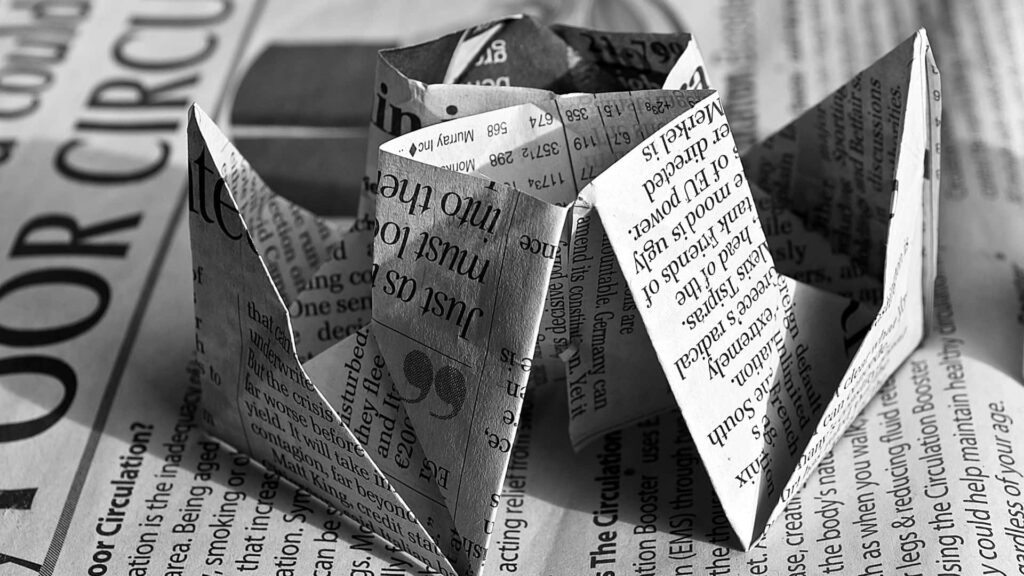 Vintage Newspaper Wallpaper with Artistic Paper Boat on Wooden Table
