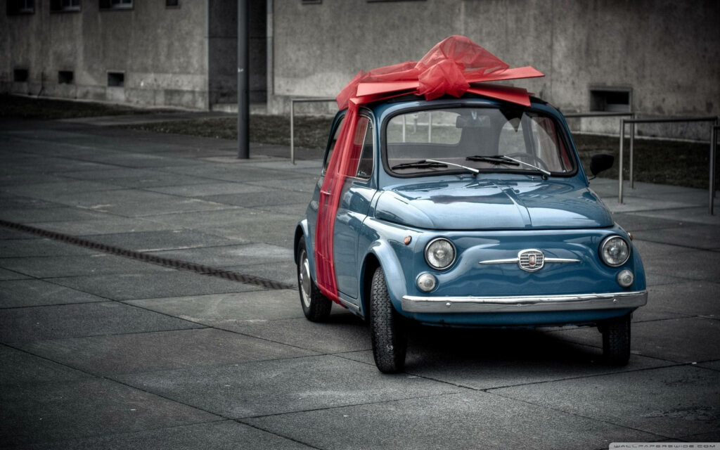 Vintage Blue Fiat 500 with Red Bow - Nostalgic Wallpaper Background