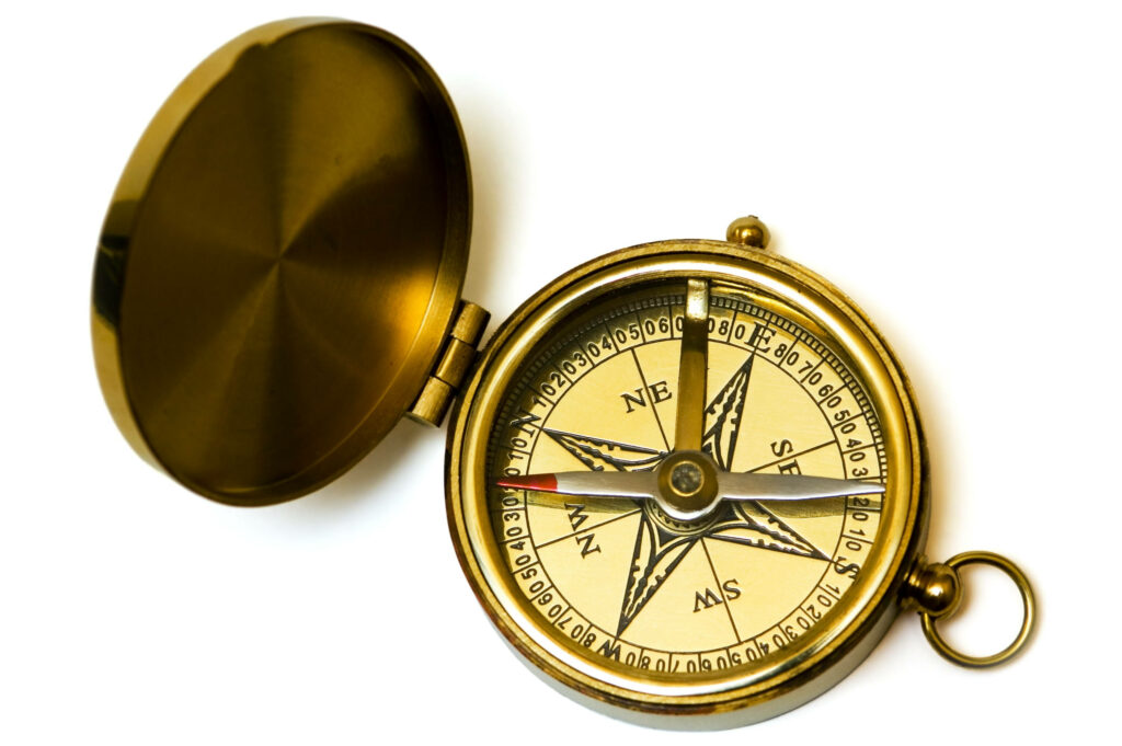 Vintage brass compass with detailed markings on white background symbolizing navigation and adventure Wallpaper