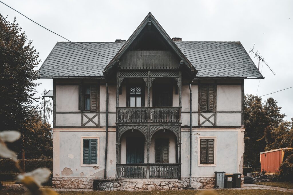 Vintage Building Wallpaper: Rustic Balcony & Lush Greenery