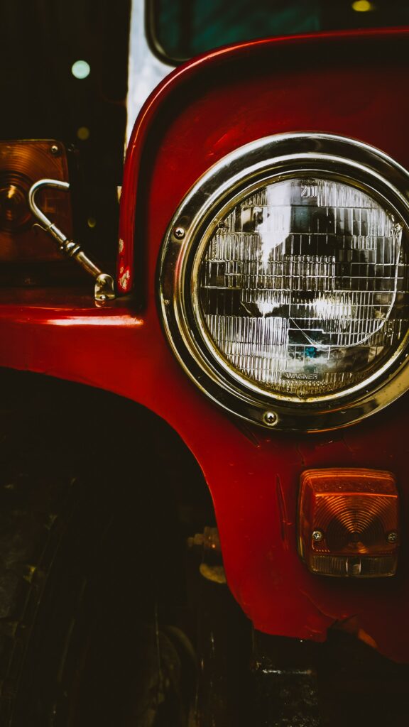 Elegant Classic Car Headlight Close-Up with Vivid Red Finish Wallpaper