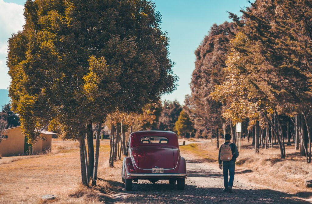 Vintage Car Parked on Rustic Road: Serene Countryside Scene Wallpaper