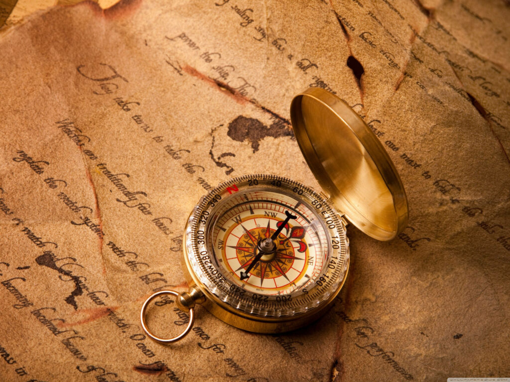Timeless Elegance: A Vintage Compass Rests on an Aging Letter Wallpaper