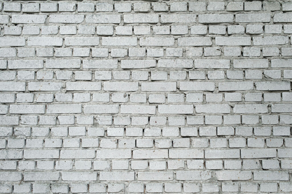 Charming English-inspired Brick Wall Amidst a Distressed, Whitewashed Background Wallpaper