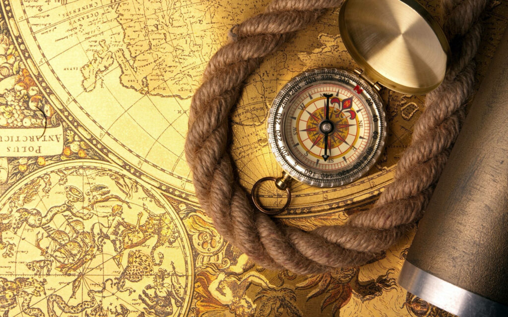 Vintage compass on detailed old map with nautical rope and brass telescope in warm tones Wallpaper