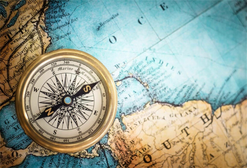 Vintage compass on old map wallpaper background classic navigation adventure exploration theme