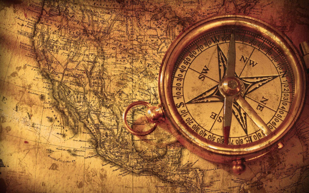 Vintage compass on sepia map wallpaper background evoking exploration adventure and navigation