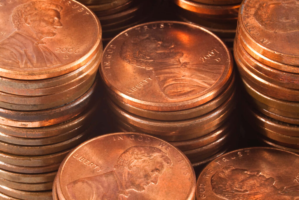 Close-up of stacked copper pennies with shiny metallic surfaces and detailed engravings wallpaper
