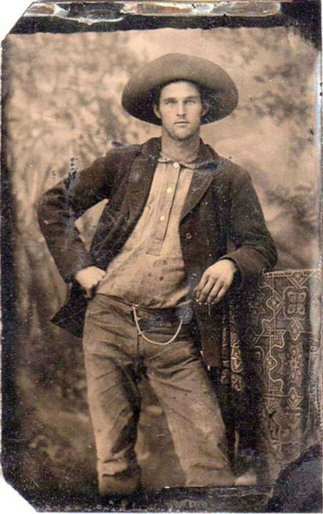 Vintage sepia photo of a classic old cowboy in Western attire with hat and rugged jacket Wallpaper