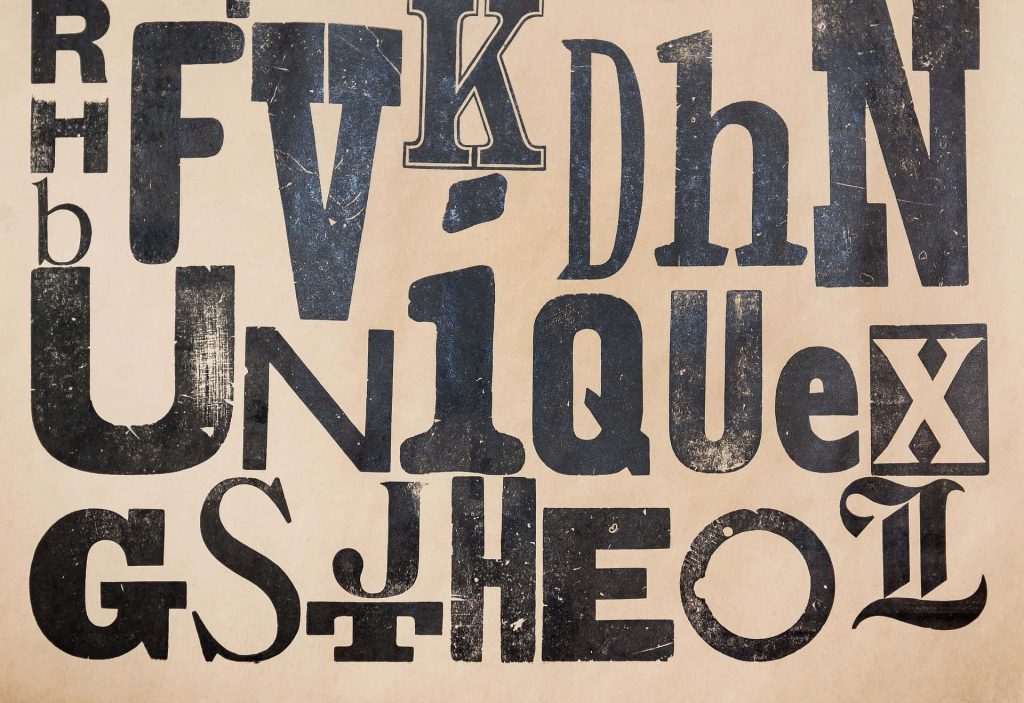 Vintage distressed black letterforms wallpaper on textured beige background industrial style