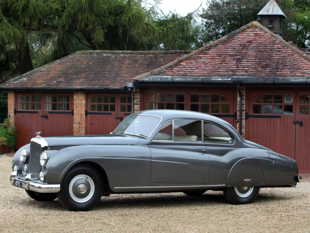 Vintage Elegance: The Timeless Gray Bentley R Type Gracefully Adorns a Historic Setting Wallpaper