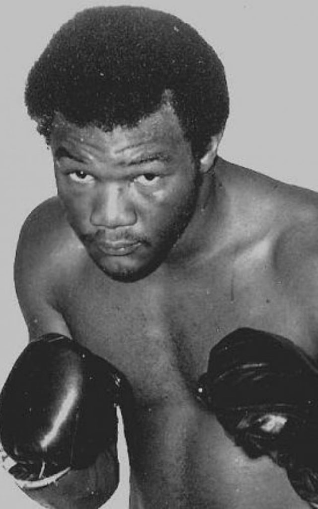 Vintage black and white wallpaper of intense young George Foreman in classic boxing pose