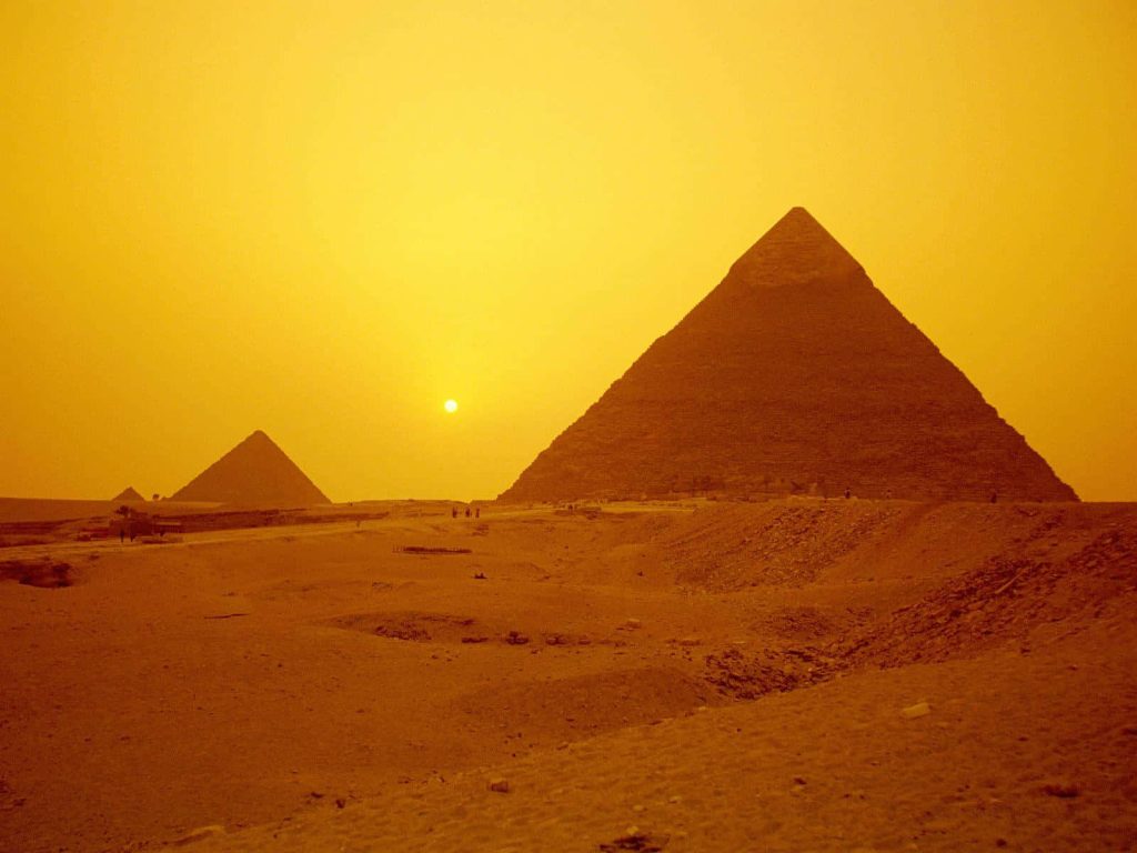 Vintage golden hour view of Giza Pyramids Great Pyramid and Khafre in serene desert wallpaper