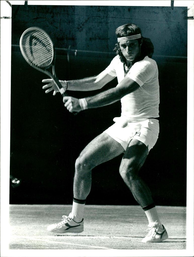 Vintage black-and-white wallpaper of tennis legend Guillermo Vilas hitting two-handed backhand