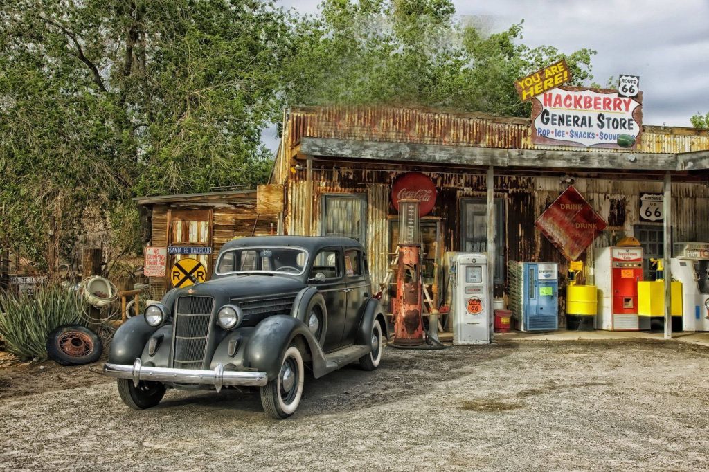Vintage black car at rustic Hackberry General Store with antique Phillips 66 pumps Route 66 sign Wallpaper
