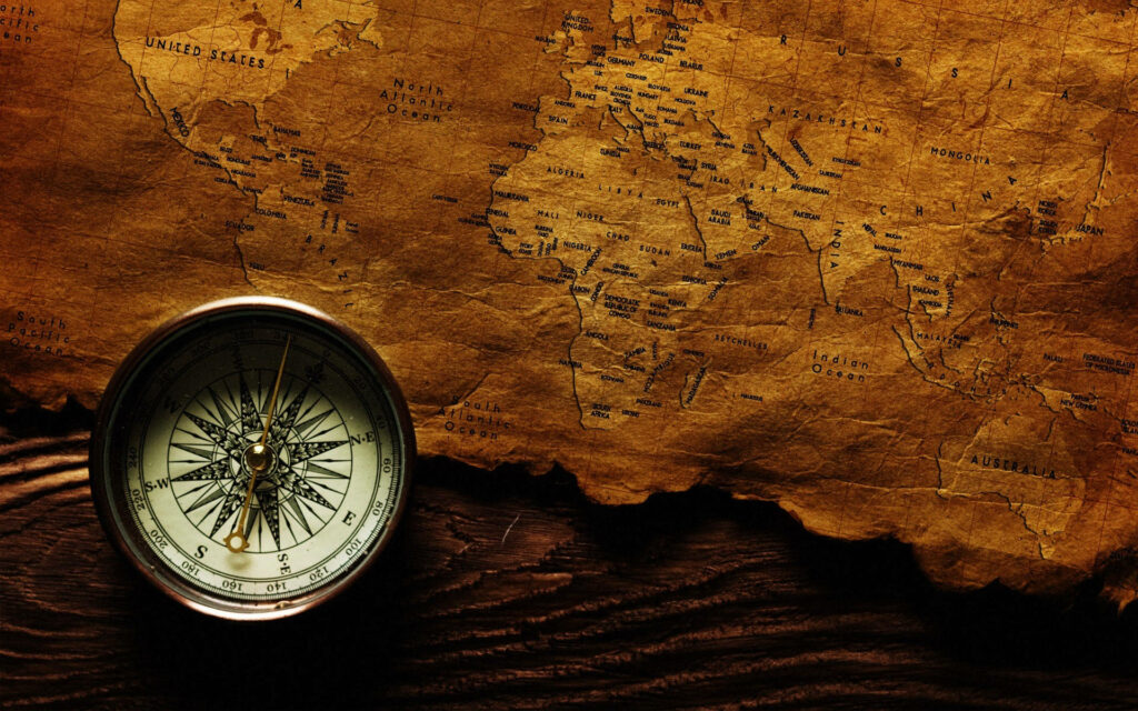Antique compass on vintage parchment with old world map sepia tones nautical exploration background Wallpaper