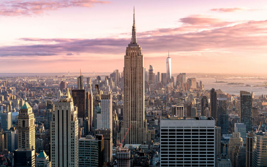 Majestic Twilight: The Enchanting Empire State Building Gleaming Amidst the Vintage New York Skyline Wallpaper