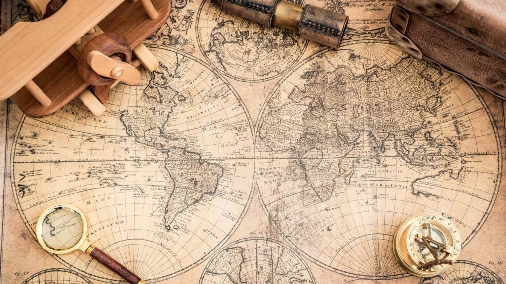 Vintage Old World map with toy plane brass telescope compass and magnifying glass background Wallpaper