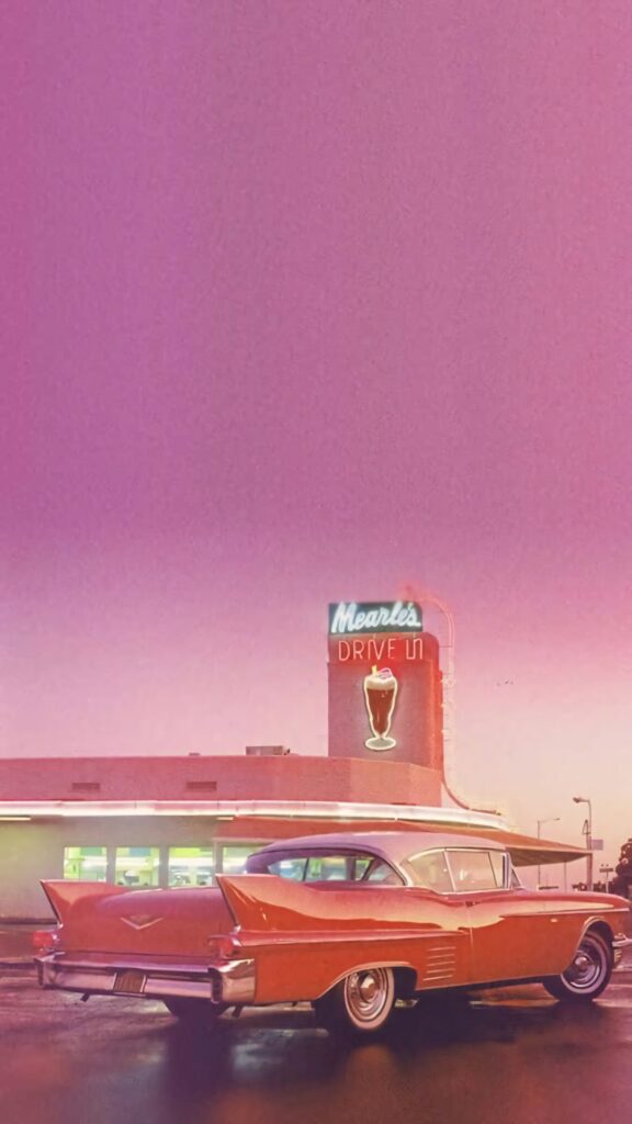 Retro pink Cadillac at Mearls Drive In under purple pink sky vintage Americana neon diner wallpaper