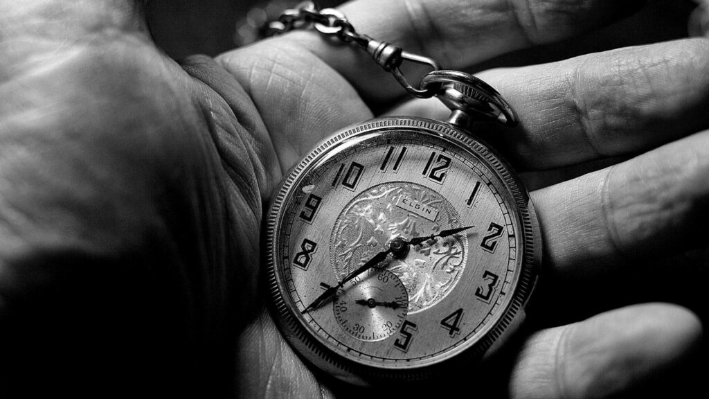 Monochrome close-up of vintage pocket watch in weathered hand detailed clockwork classic numerals Wallpaper