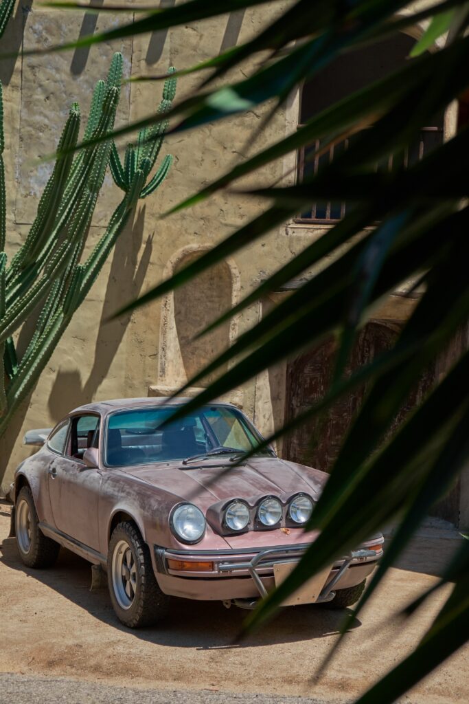 Vintage Porsche 911 Front View Wallpaper with Scenic Greenery